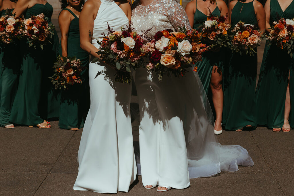 Brides and their bridesmaids pose with bouquets in hand