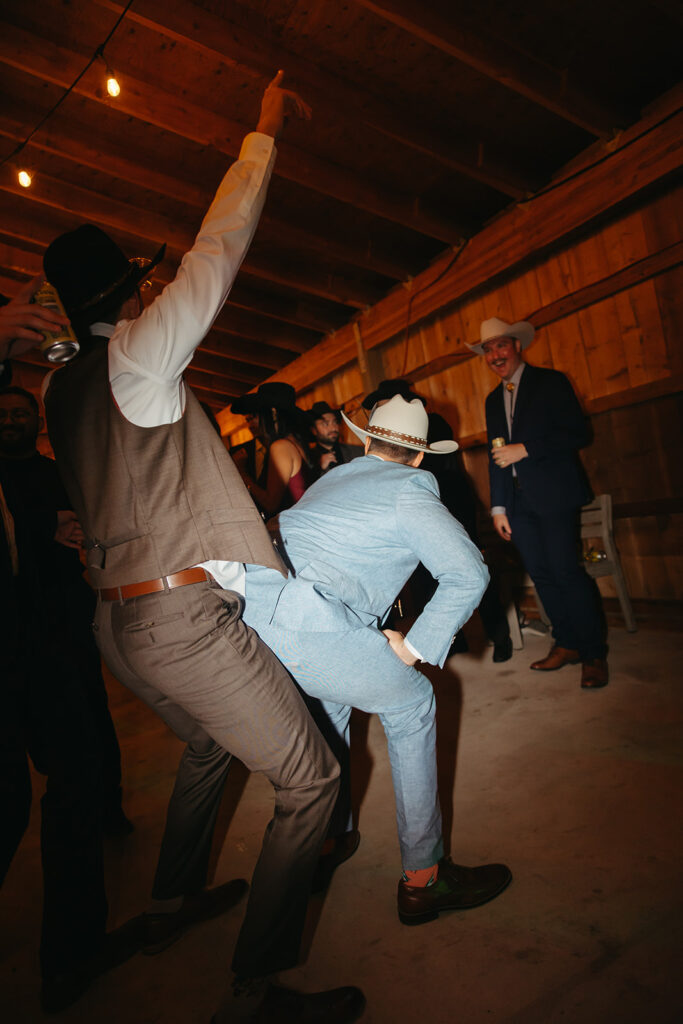 Wedding guests dance raucously on dance floor