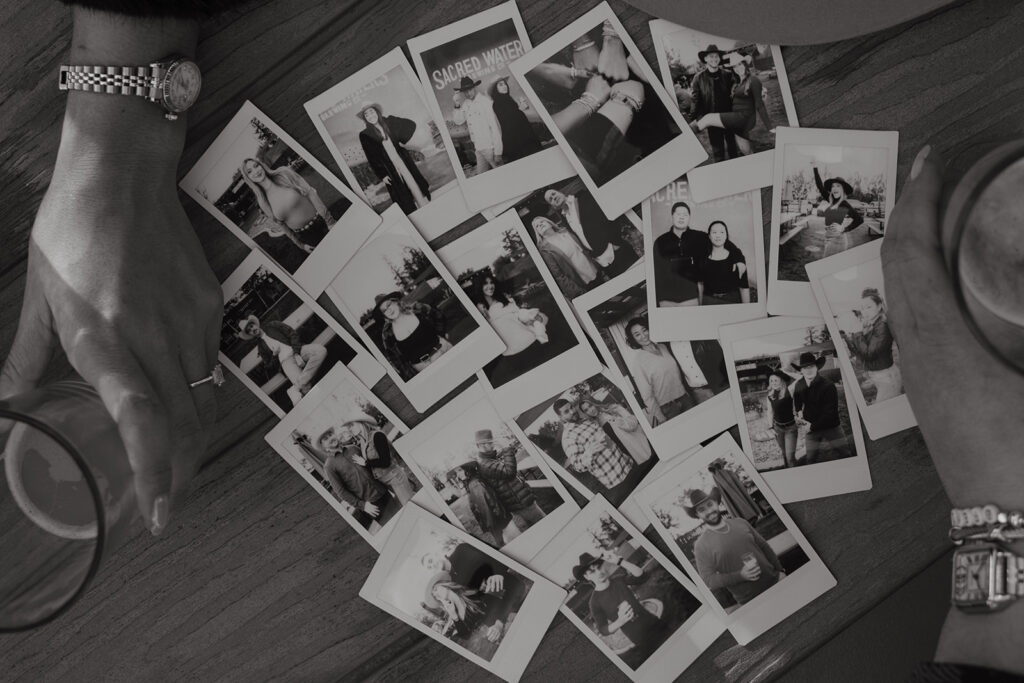 Polaroids and craft beers laying on picnic table. 