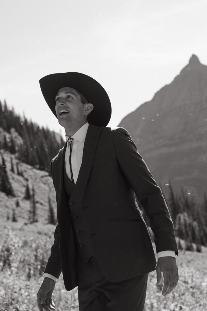 Groom in bolo tie and Inchigo suit looks up at the sky.