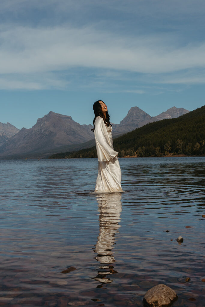 Bride stands in glacial water in Montana. 