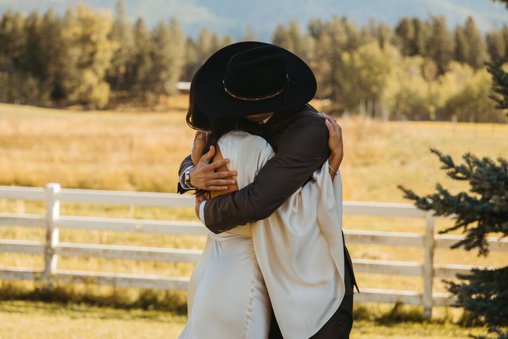 Bride and groom embrace during first look at their Yellowstone wedding in Glacier National Park.