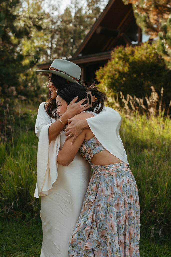 Bride hugs her sister in sweet embrace. 