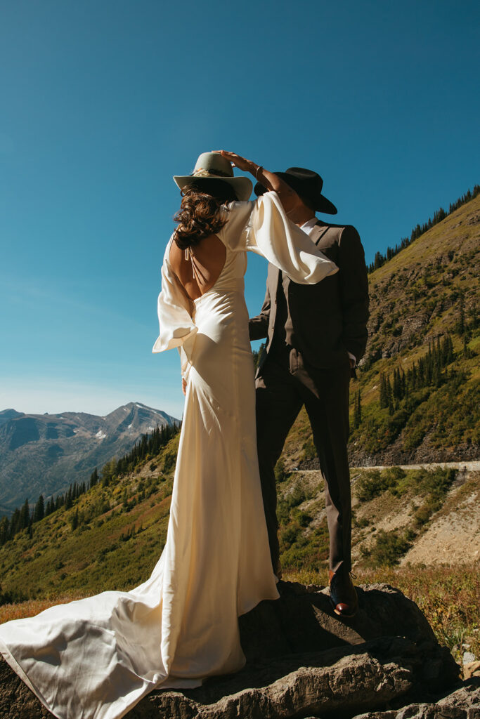 Bride and groom stand overlooking the vista in Glacier National Park before their Yellowstone wedding.