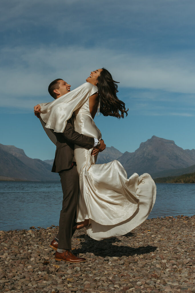 Groom twirls bride through the air in Yellowstone wedding photographs.