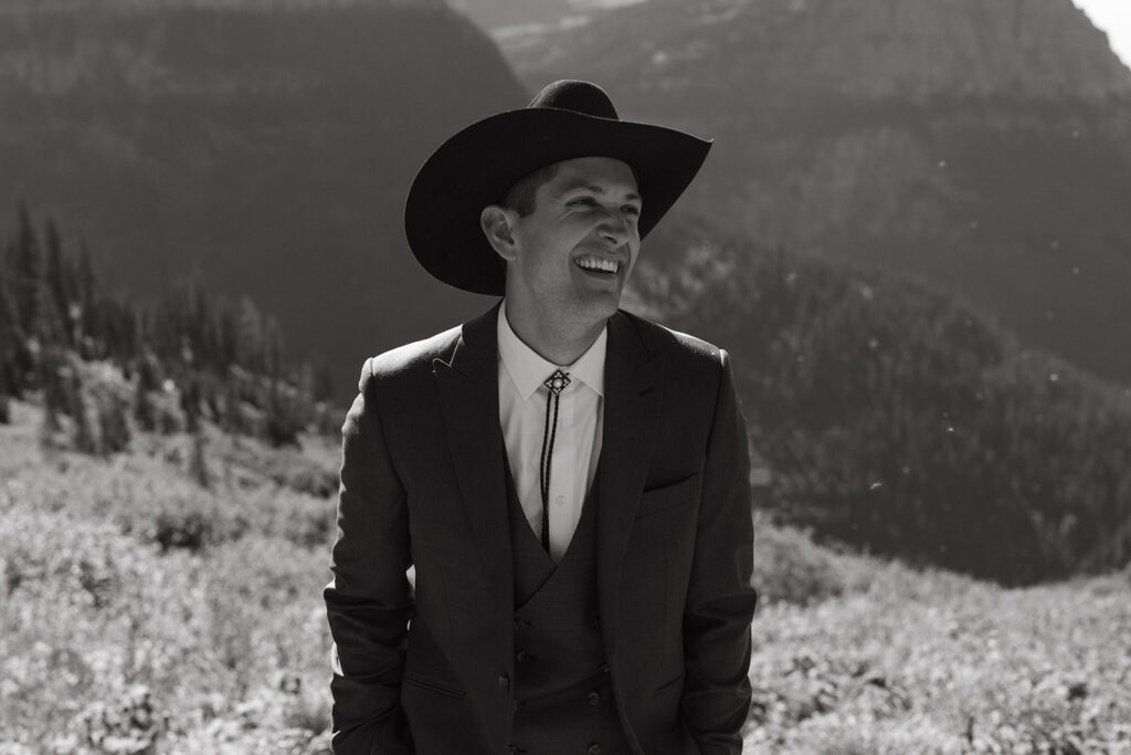 Groom smiles at his bride in Glacier National Park for Yellowstone wedding in Montana.