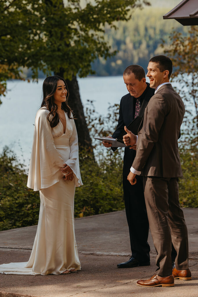 Groom laughs at something the officiant said and looks at the guests. 