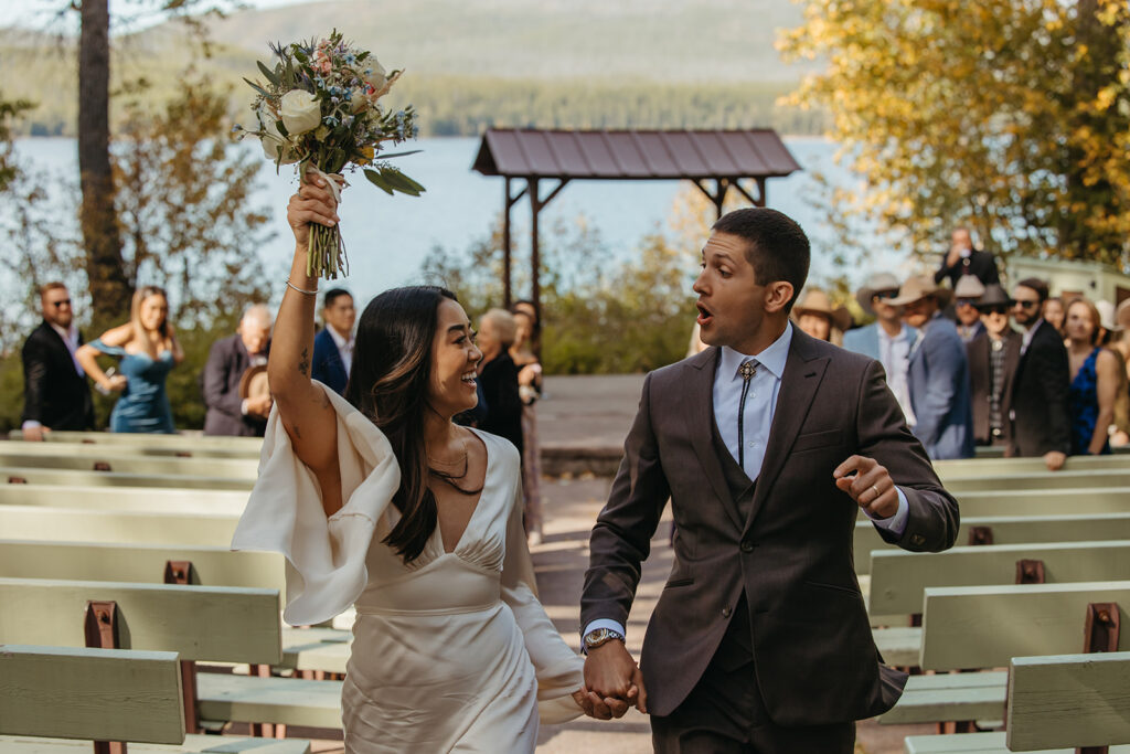 Bride and groom come back down the aisle in a celebratory fashion.