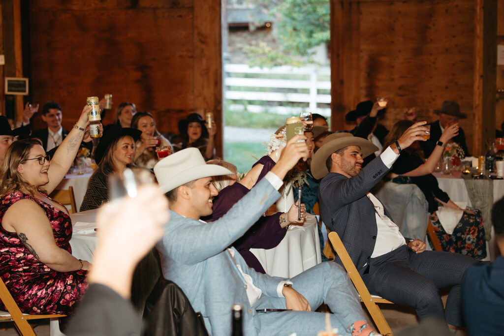 Wedding guests raise their Modelo beers in a toast to newlyweds.