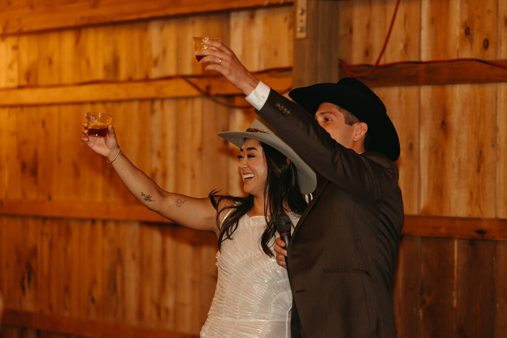 Newlyweds raise their glasses in a toast during Yellowstone wedding reception