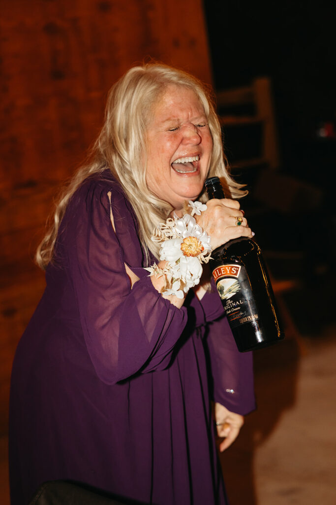 Wedding guest sings into a bottle of Bailey's