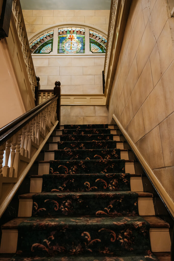 Stunning stairwell leading to stained glass window at Riverwood Mansion in Nashville