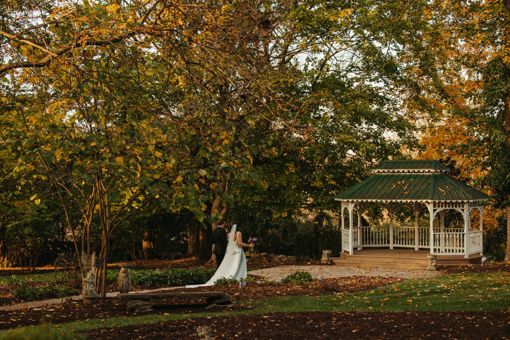 Bride and groom walk towards stunning green-roofed gazebo at Riverwood Mansion in Nashville