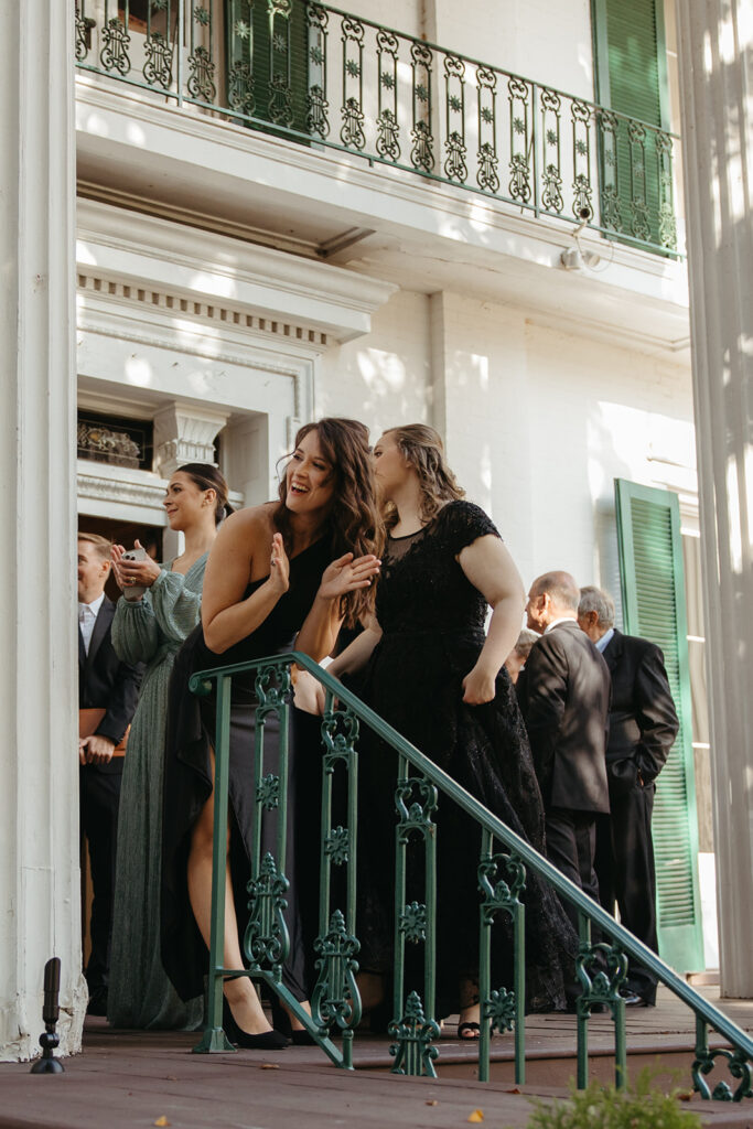 Bride's friends peer around the corner to watch the first look