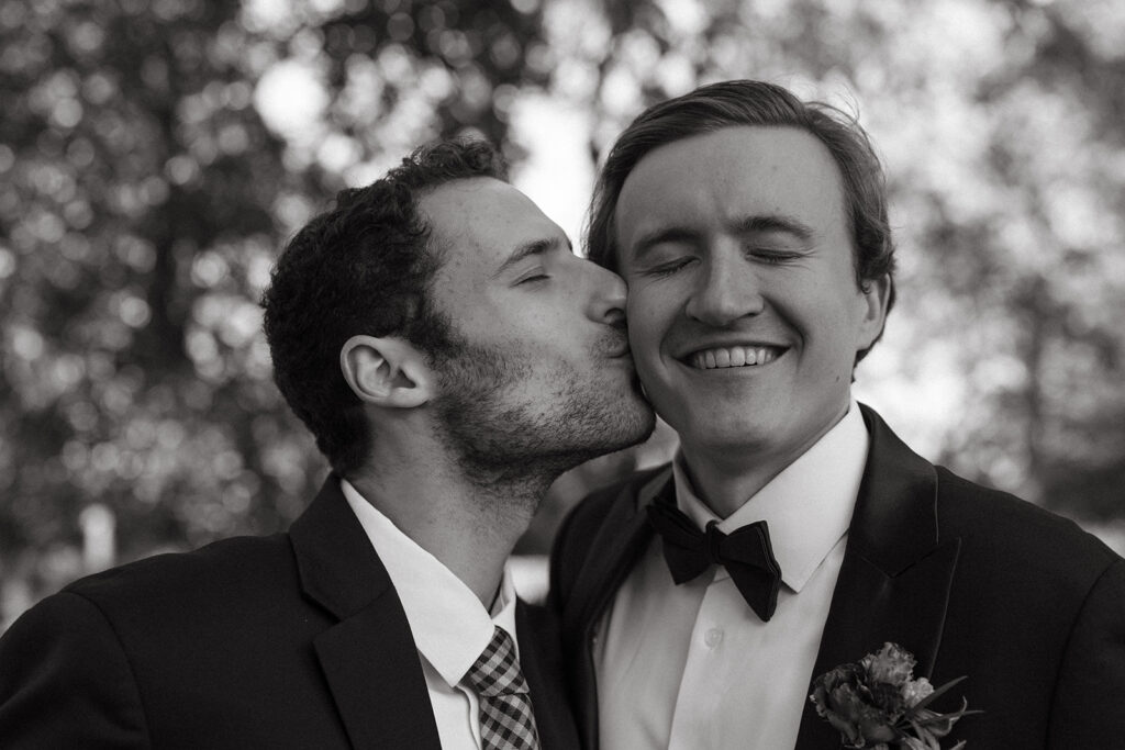 Friend kisses groom's cheek