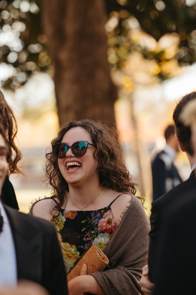 Woman at black tie wedding in Nashville laughs during cocktail hour