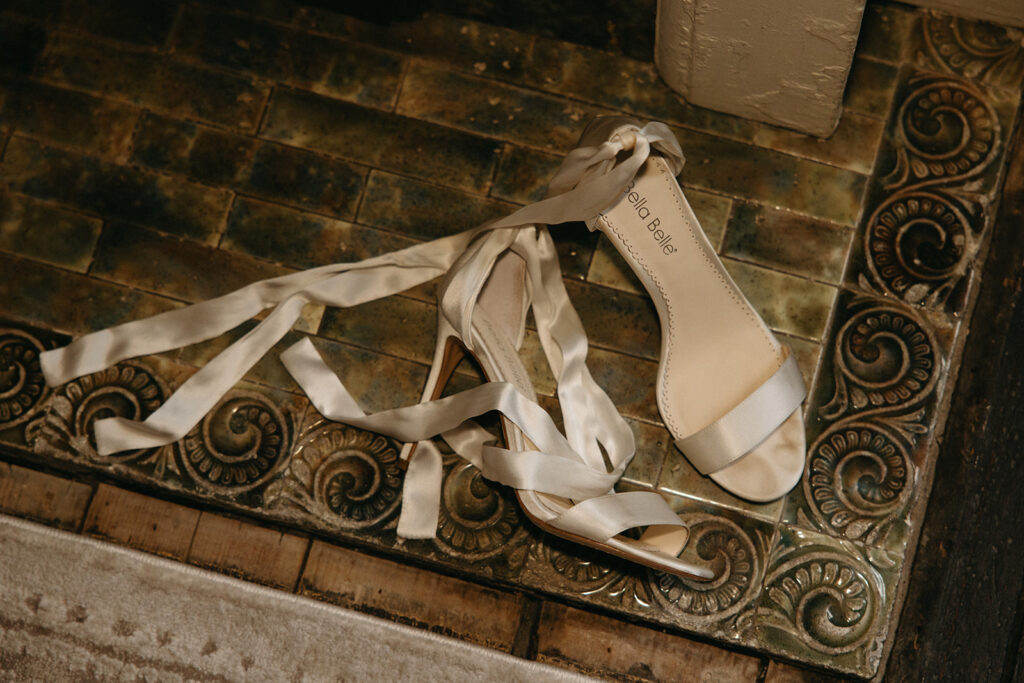 Bride's shoes lay on vintage detailed floor of historic wedding venue in Nashville