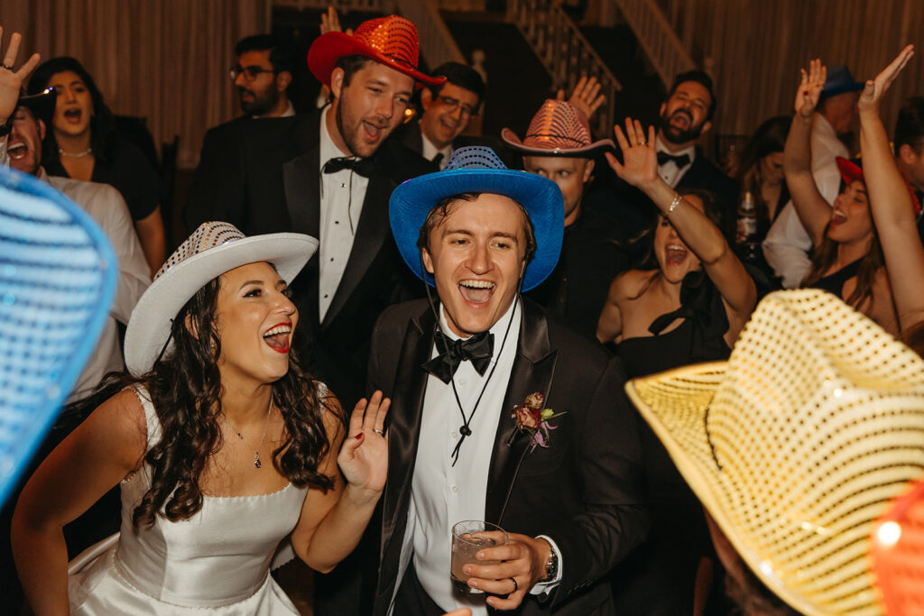 Bride and groom enjoy black tie wedding reception surrounded by all of their friends and family