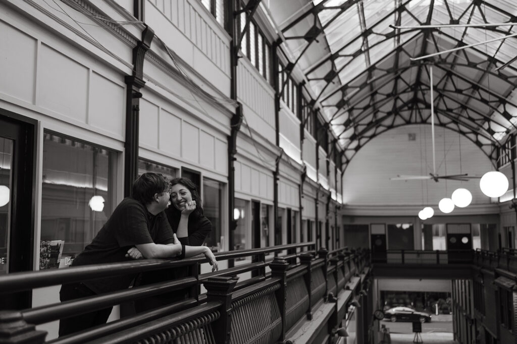 Woman looks lovingly at her fiance as they look over the balcony at The Arcade Nashville