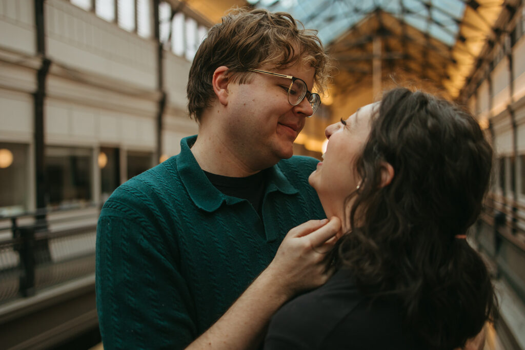 Man tilts woman's chin up to kiss her