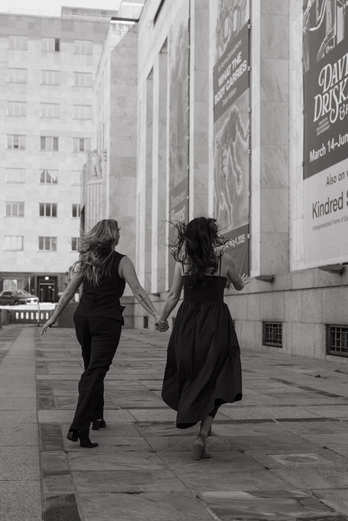 Engaged couple runs outside Frist Art Museum in downtown Nashville