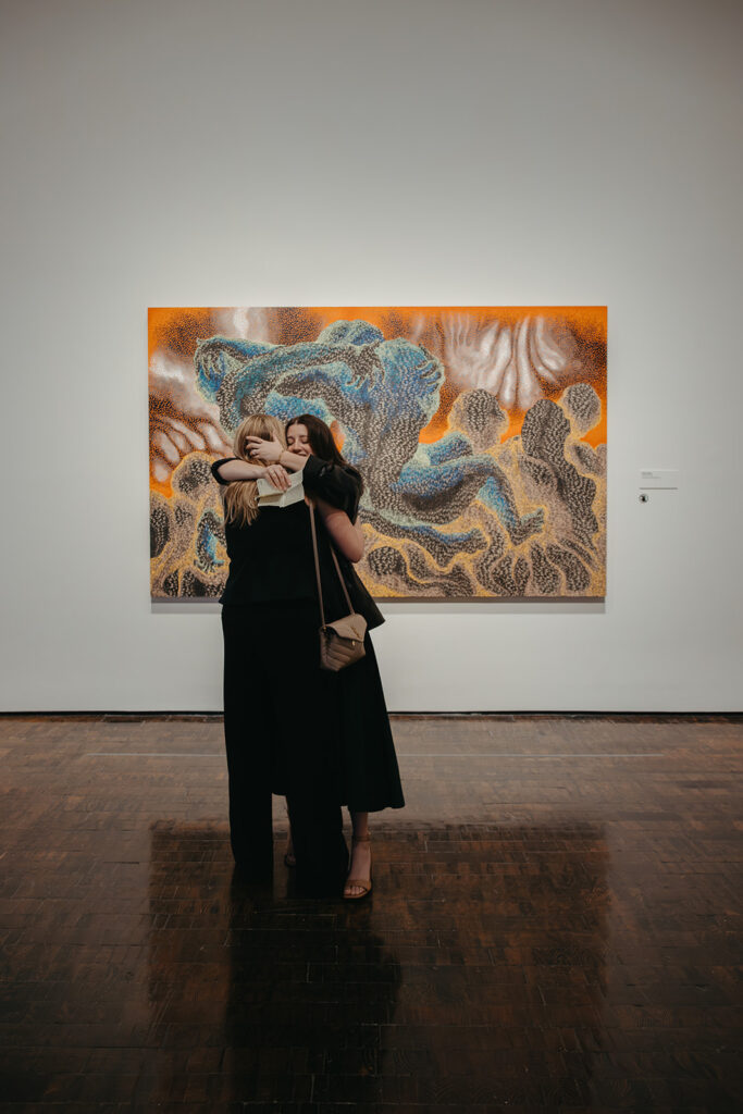 Couple embraces in front of artwork at Frist Art Museum in downtown Nashville