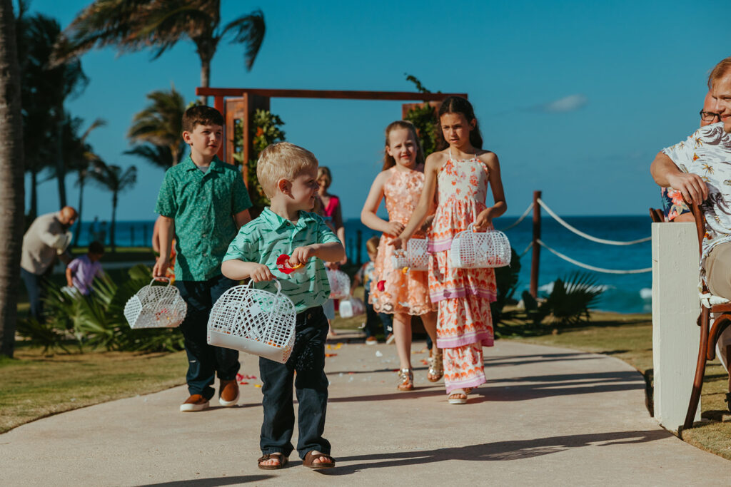 Flower girls and ring bearers sprinkle colorful flower petals down the aisle of destination wedding in Cancun, Mexico