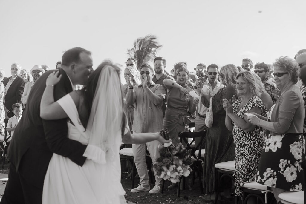 Bride and groom embrace to a chorus of cheers