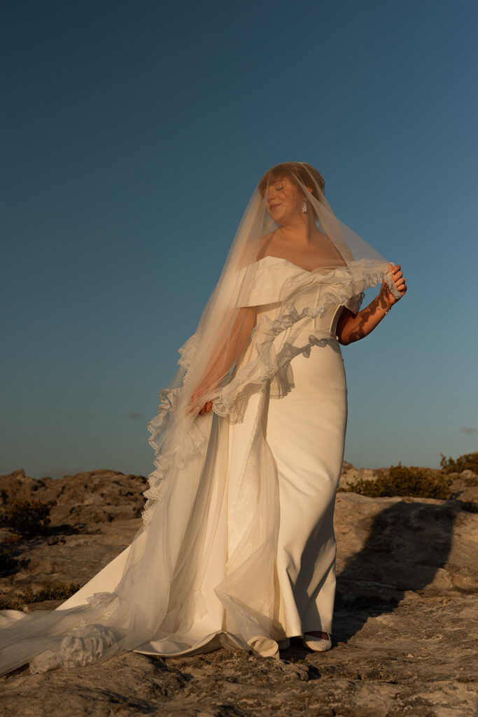 Bride stands in the golden hour sunlight at destination wedding in Mexico