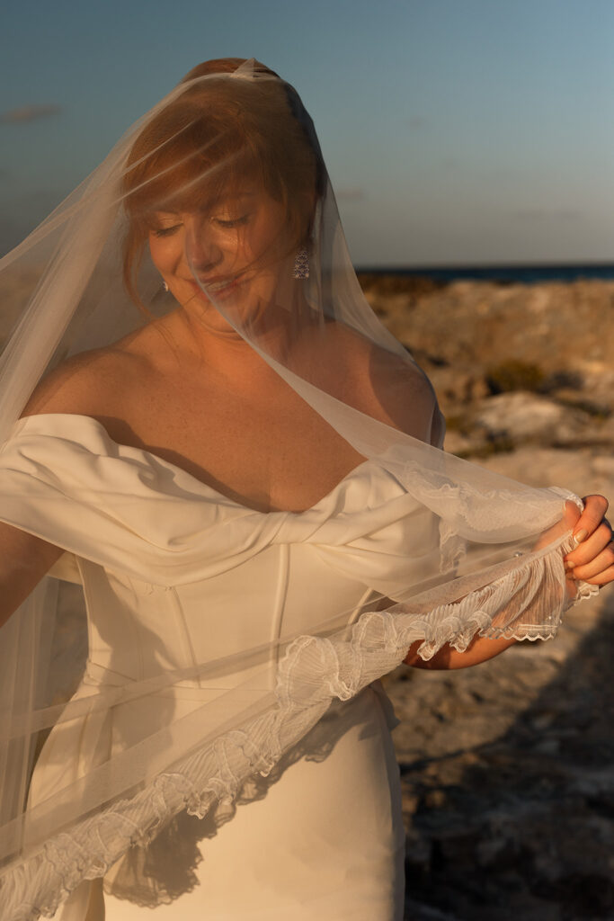 Bride stands washed in receding sunlight at destination wedding in Mexico