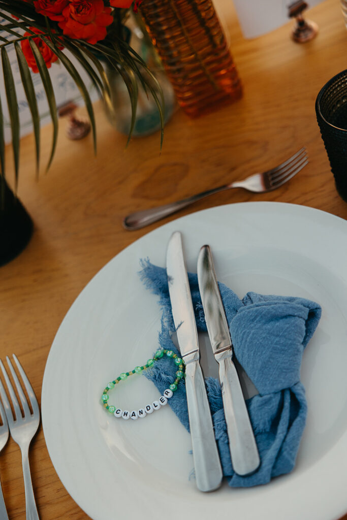 Personalized friendship bracelets mark each spot at dinner table at destination wedding in Mexico