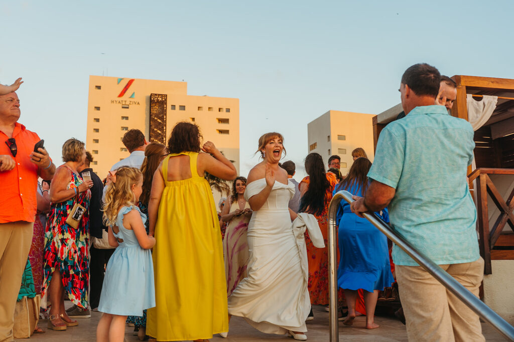 Bride shrieks with glee as she greets her guests at destination wedding reception in Mexico