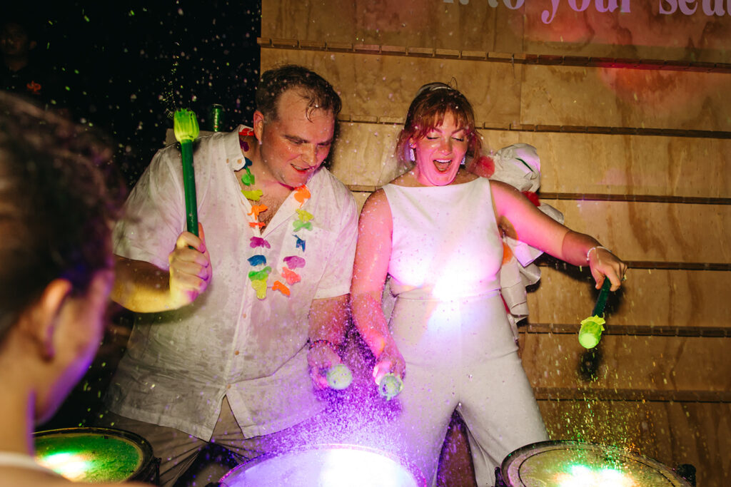 Bride and groom play the bongo drums at destination wedding in Mexico