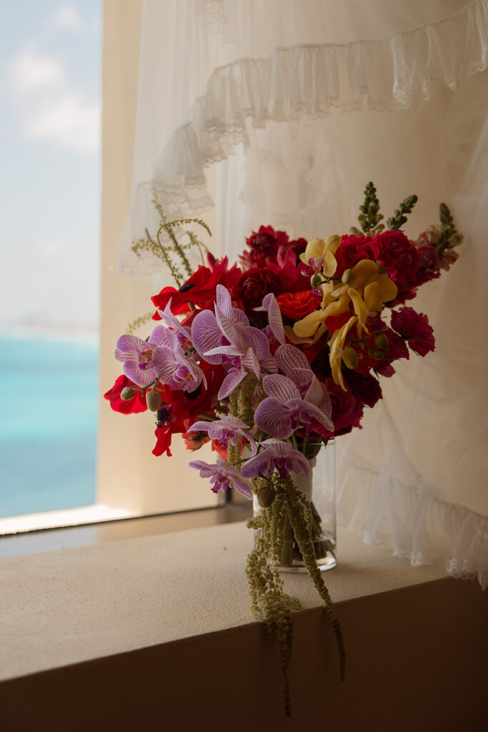 Colorful, tropical bridal bouquet sits in windowsill