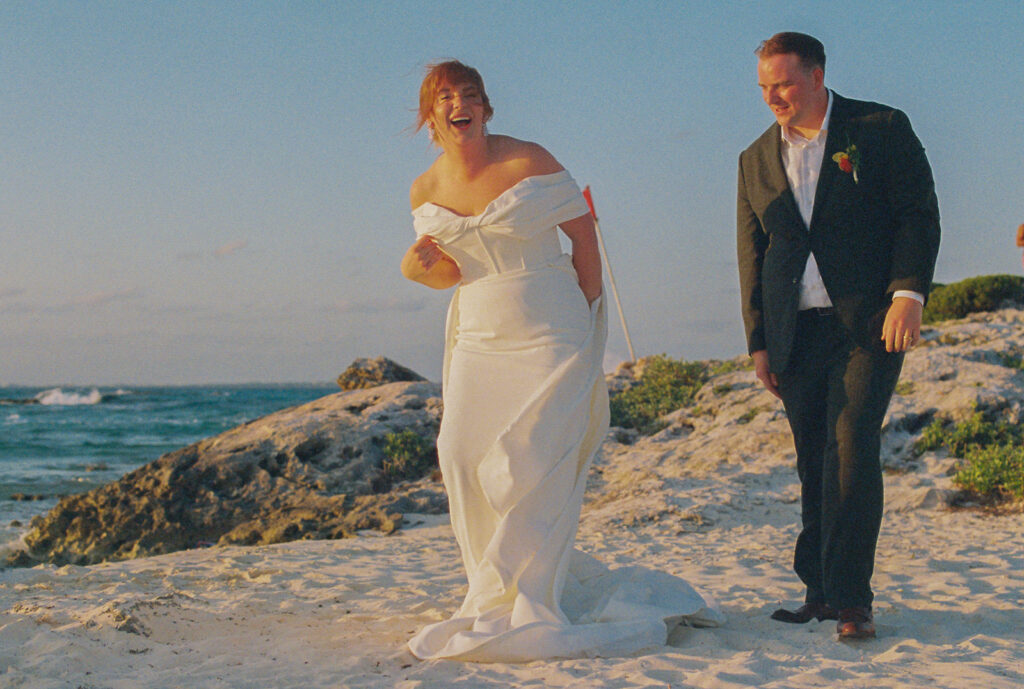 Bride and groom romp and play in the sand at destination wedding in Mexico
