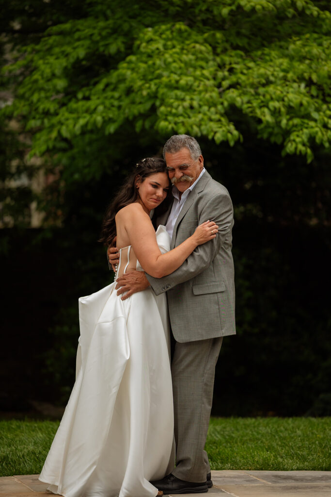 Bride dancing with her father under the trees
