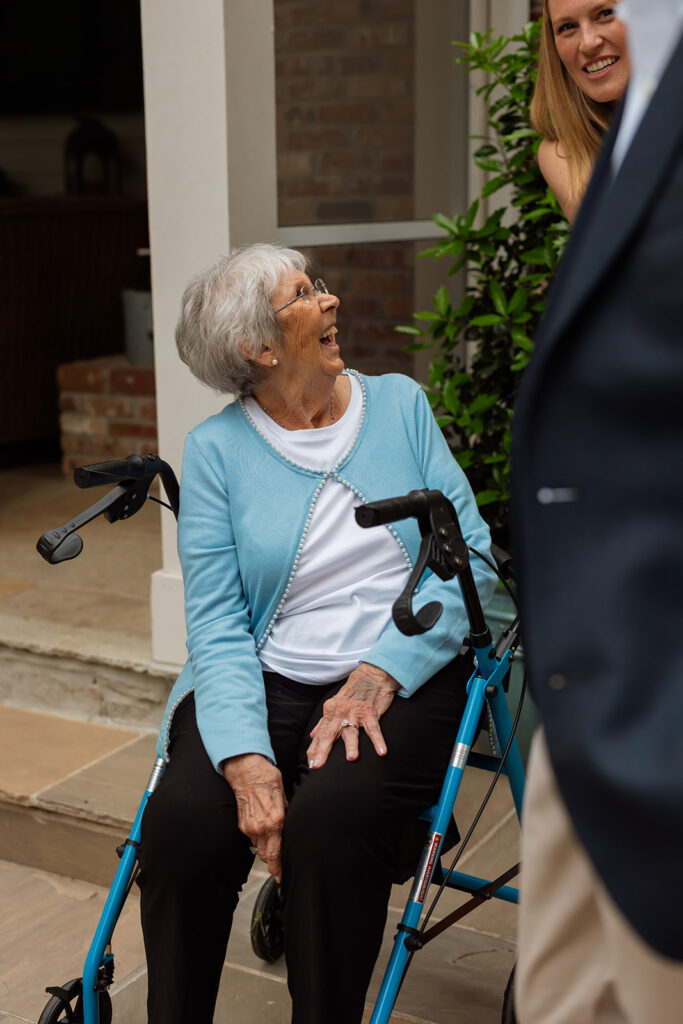 Bride’s grandmother smiling while seated with family at the Tennessee backyard wedding