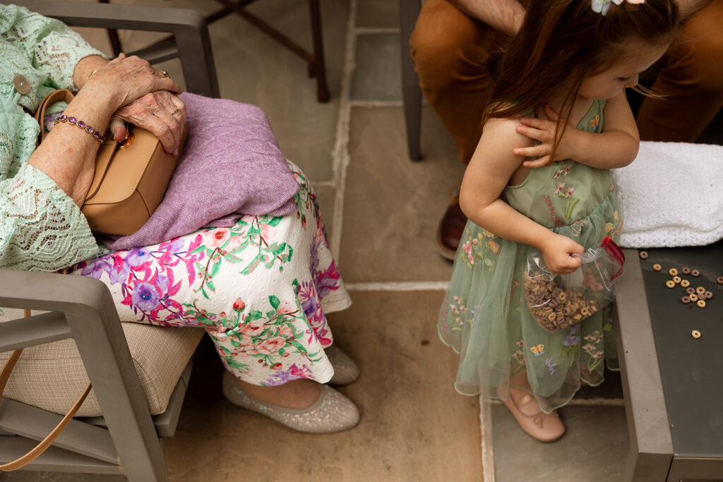 Grandmother and flower girl sharing a quiet moment before the backyard wedding in Tennessee