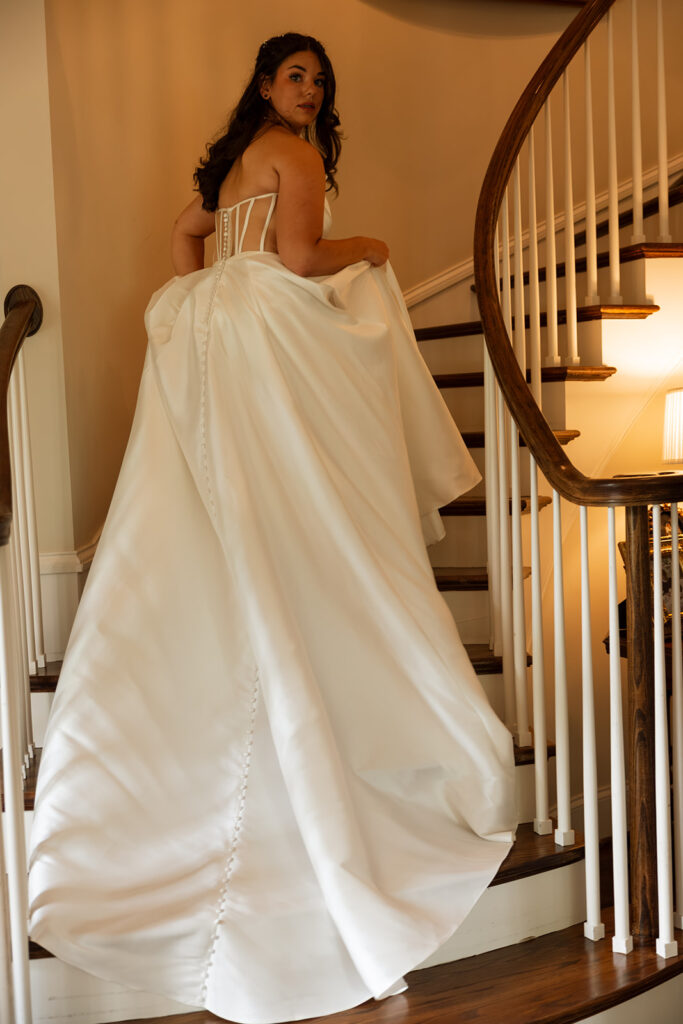 Bride ascending the staircase in her gown on the morning of her backyard wedding
