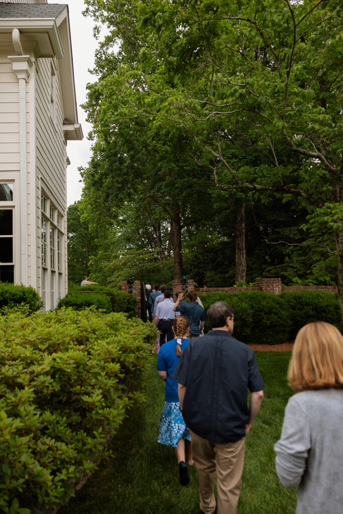 Guests walking through the lawn path on the way to a backyard wedding ceremony in Tennessee