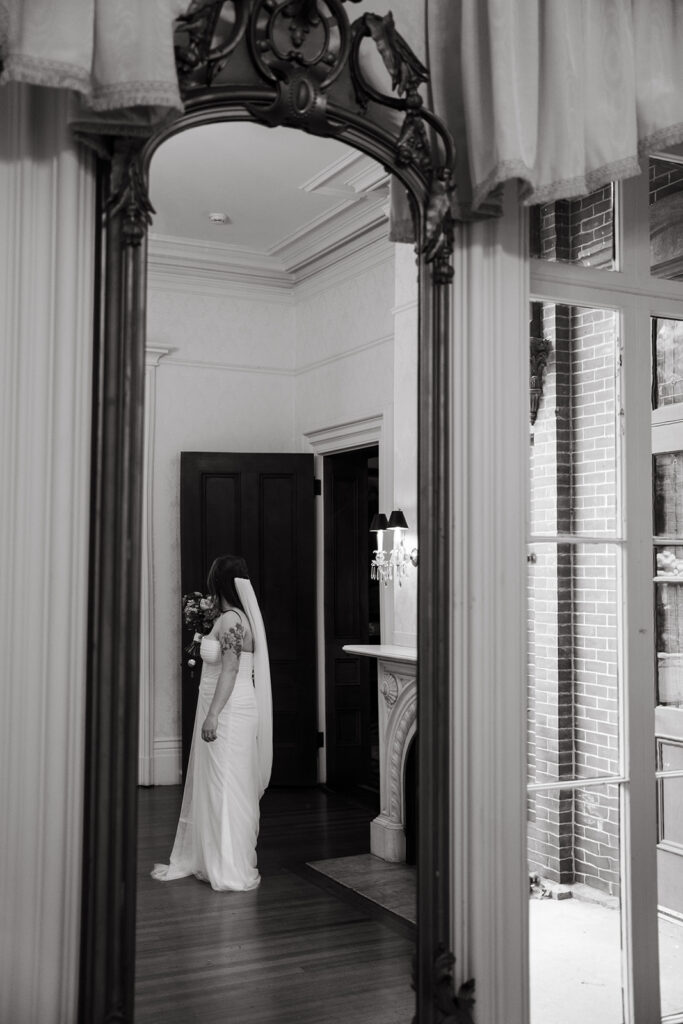 Bride framed in arched doorway at Commander’s Mansion, veil trailing dramatically behind.