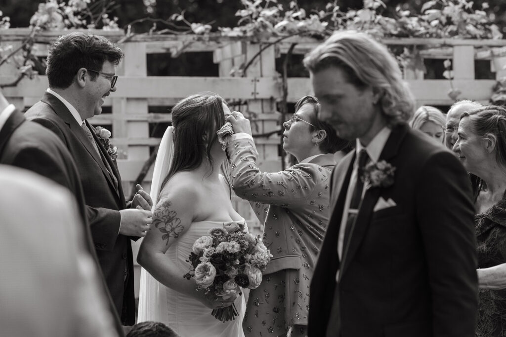 Film wedding photography of sister of the bride helping fix bride's makeup