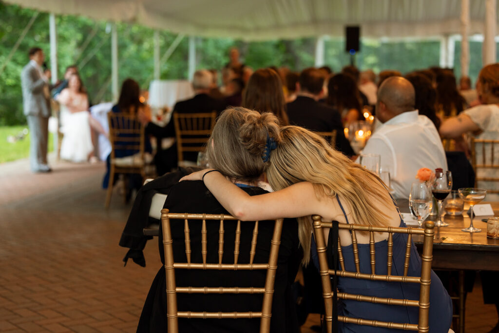 Guests leaning in close at their table, emotional candid moment.