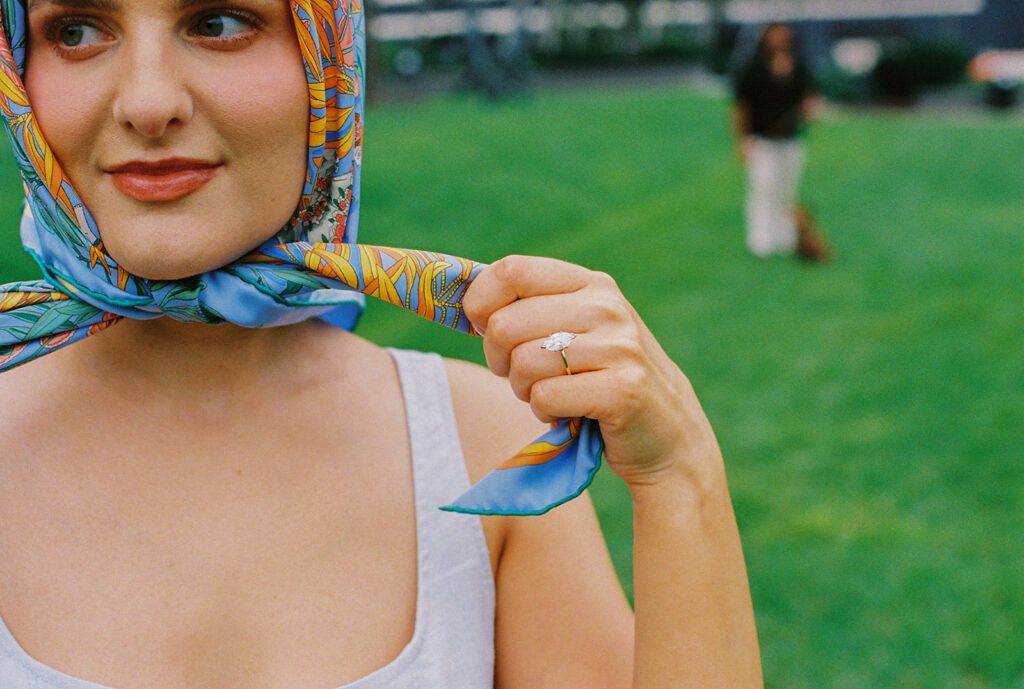 Close-up of bride’s face under patterned scarf, playful vintage-inspired portrait.