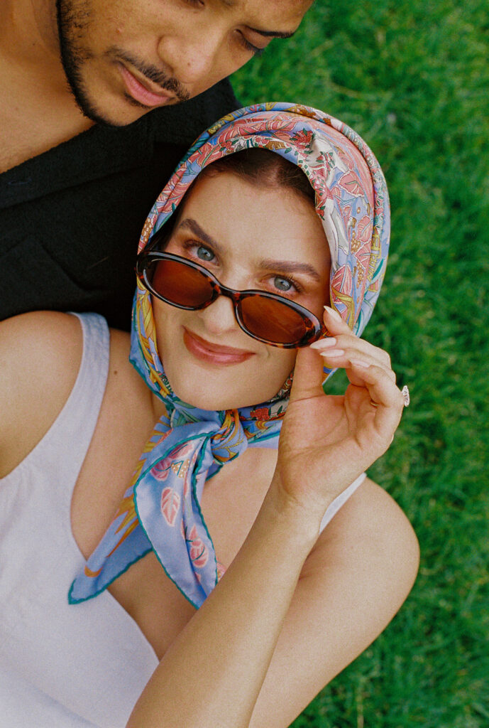 Bride wearing a patterned headscarf and sunglasses, channeling vintage Sophia Loren vibes.
