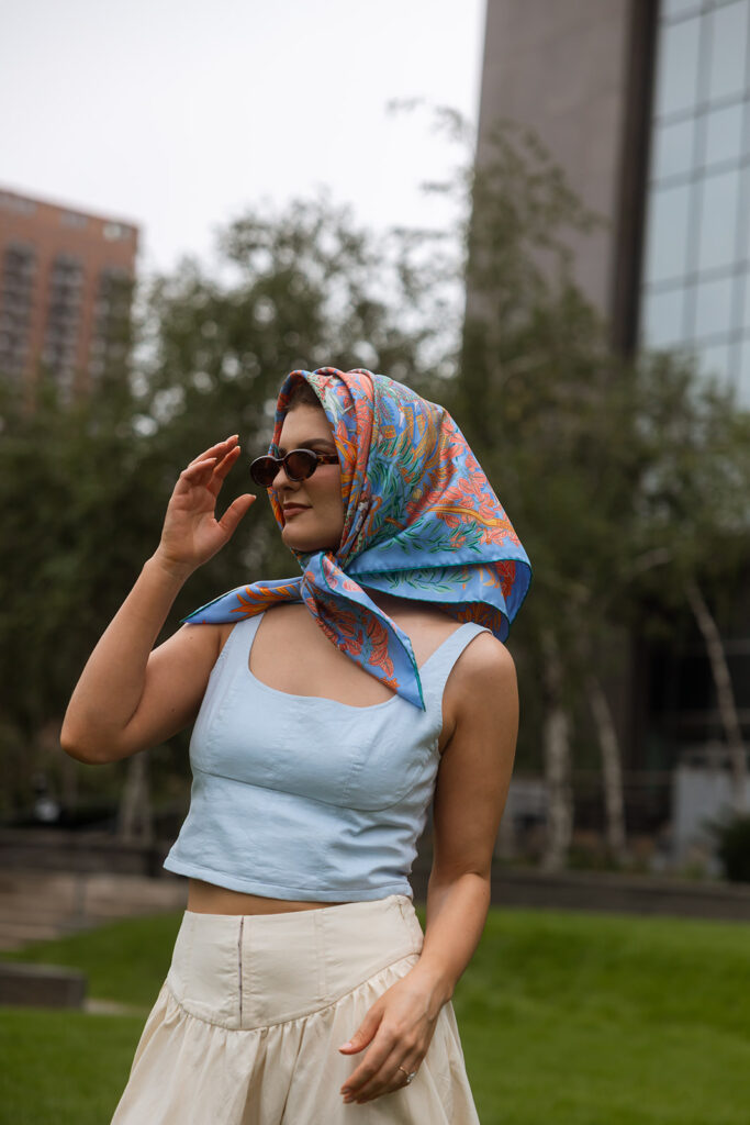 Bride laughing in scarf and sunglasses during playful styling moment.