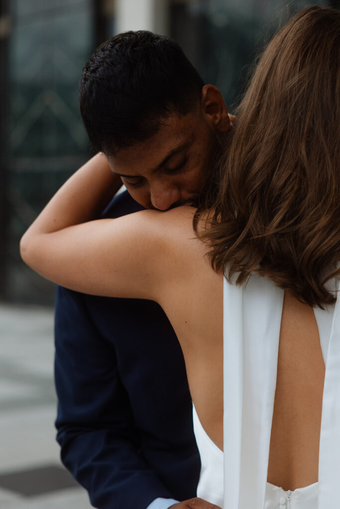 Groom resting his head on fiancée’s shoulder in a quiet, intimate pose.