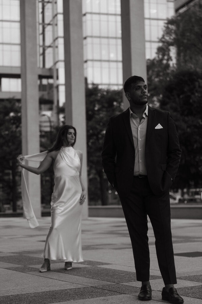 Groom walking confidently beside fiancée in flowing gown, stylish Minneapolis engagement photography.