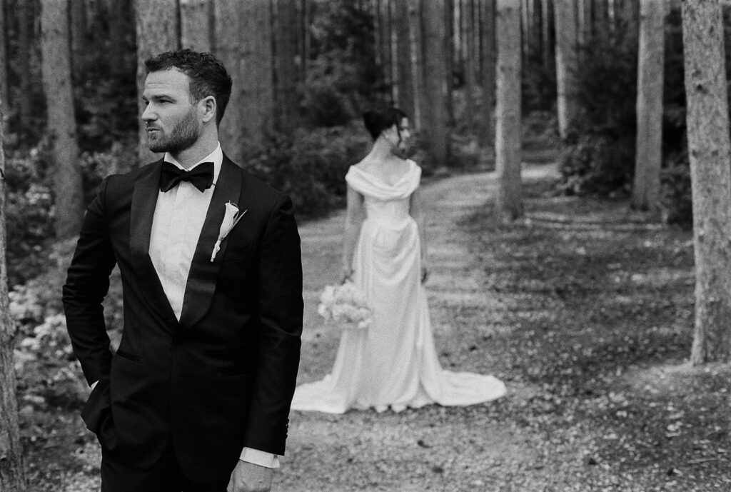 Groom in focus, bride in the background — one of my favorite groom portraits posed wedding photography of all time.
