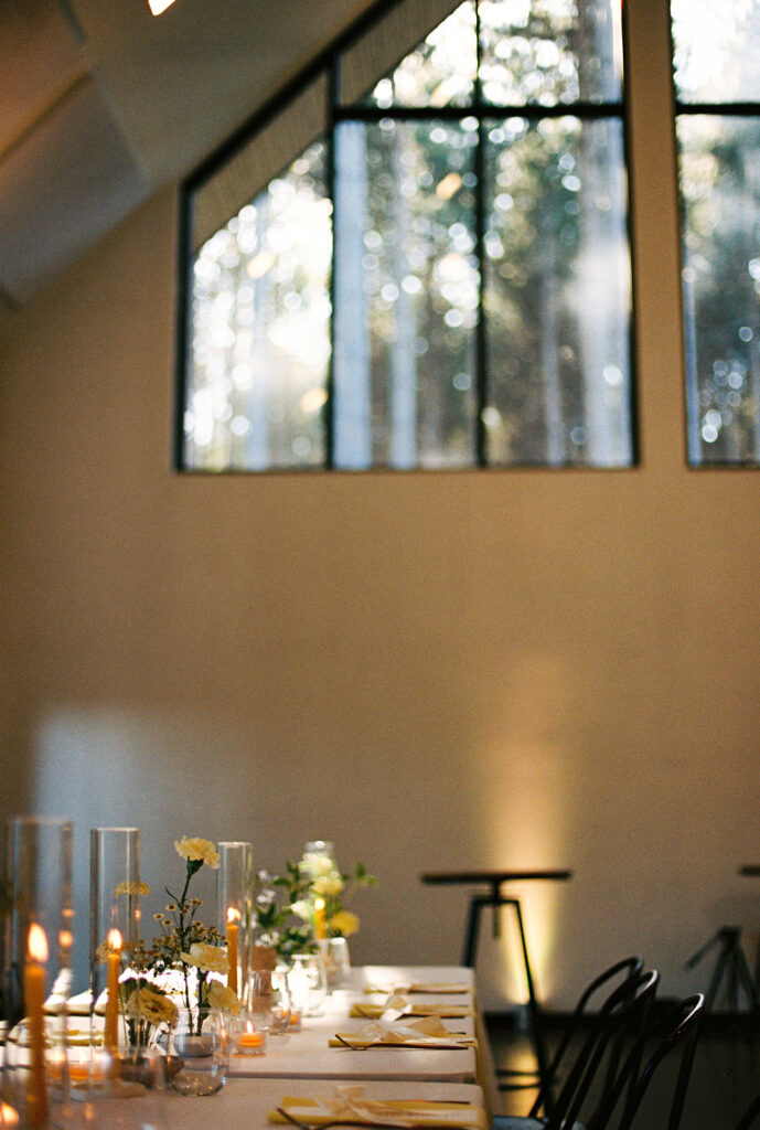 The reception space at Pinewood glows in the evening light, each table set for connection and conversation.